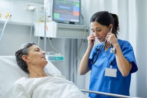 A nurse is putting the stethoscope on her ears to examine a patient